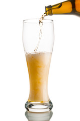 Beer pouring from bottle into glass isolated on white background