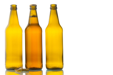 One bottle with beer and two empty beer bottles isolated on white background
