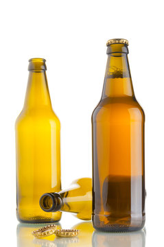 One bottle with beer and two empty beer bottles on white background