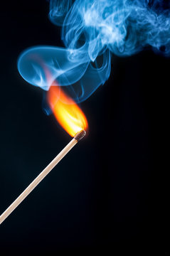 Ignition match with smoke closeup on black background