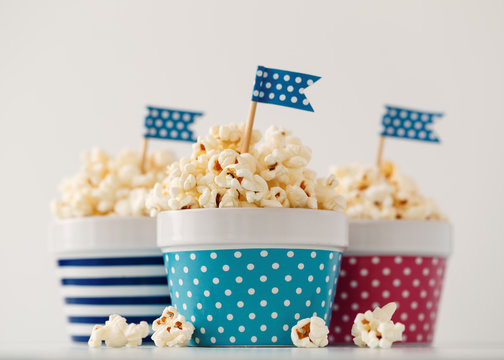 Homemade Buttered Popcorn Served In Colorful Bowls Decorated With Party Flags. 