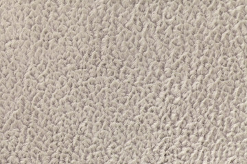 Beige background of soft, fleecy cloth. Texture of textile closeup