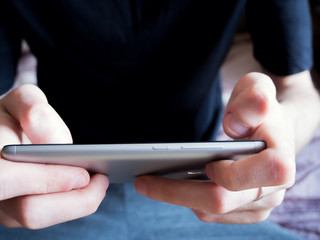 young man playing phone on the sofa
