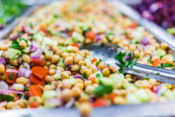 Chickpea salad in tray in bar with spoon