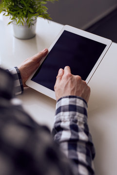 Man in a checkered shirt using digital tablet