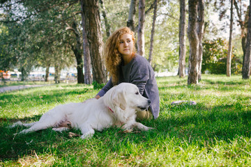 Young female playing with labrador retriever dog in park