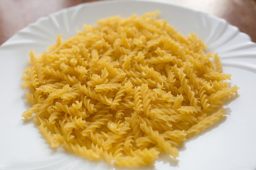 Delicious italian spiral pasta fusilli on white background