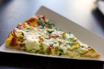 Pizza with cheese, tomatoes, sausage and greenery in individual substrate, fast food restaurant