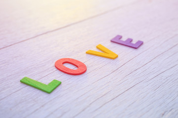 Colorful wooden alphabet and LOVE word. Top view on white wooden