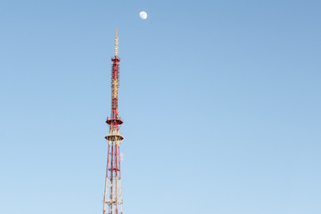 TV tower and moon against the blue sky