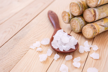 Rock sugar and sugar cane on wooden table background