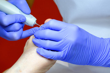 Obraz premium Pedicure specialist works with the patient in clinic