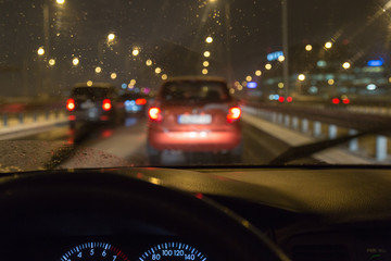 Driving a car in a bad weather, in traffic jam