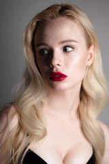Fototapeta premium Beauty model girl with perfect make-up red lips and blue eyes looking at camera, wearing magenta bra. Portrait of attractive sexy young woman with blond hair. 