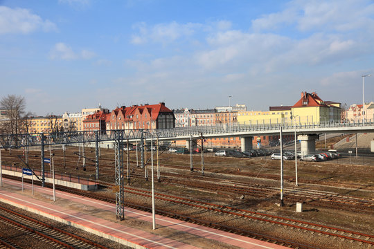 Fototapeta Szyny kolejowe, perony na dworcu w Opolu, zabytkowe kamienice.