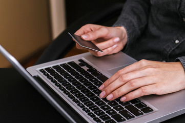 Close-up woman's hands with a credit card and using computer keyboard for online shopping