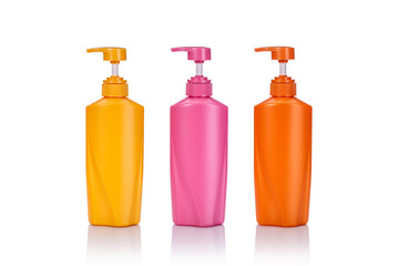 Blank yellow, pink and orange plastic pump bottle used for shampoo or soap. Studio shot isolated on white