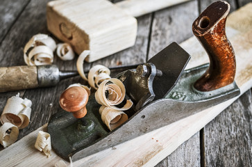 Old carpentry tools hammer, chisel, plane on an old board