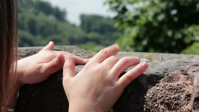 Child Pretending To Play Piano On Rock Outdoor.
