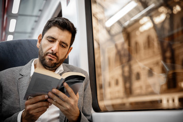Businessman reading a book - obrazy, fototapety, plakaty