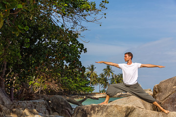 Man on the beach  doing yoga.
