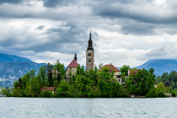 Fototapeta na wymiar Lake Bled with St. Marys Church of Assumption on small island. Bled, Slovenia, Europe. Mountains and valley on background. Areal view from above.
