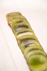 Sliced kiwi slices on a light wooden background