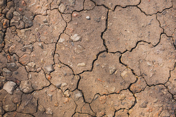 Closeup of cracked stony earth. Brown nature background. Horizontal color photography.