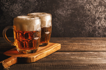 Cold beer in glass with chips on a dark background.