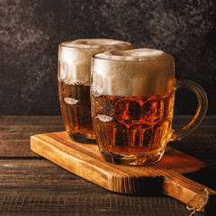 Cold beer in glass with chips on a dark background.