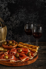 Prosciutto, cracker, bread sticks with red wine.