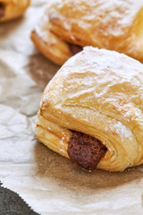 Puff pastry dessert with chocolate filling on baking paper