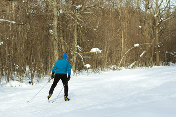 A man performs sports in the winter forest.
