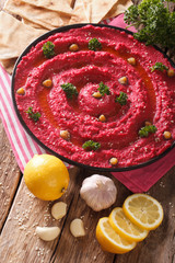 Homemade hummus of beet, chickpeas and pita bread close-up. vertical