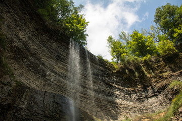 upward view of a waterfall in front of blue sky
