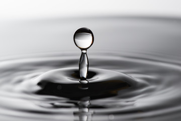 Fototapeta na wymiar Water drop falling into water making a concentric circles 