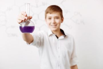 Positive happy boy holding a chemical reagent