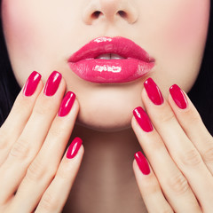 Makeup Lips with Pink Glossy Lipstick and Pink Nails. Shiny Lips and Hand with Manicure