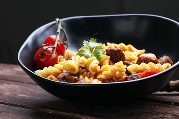 beef goulash, a stew that originated in Hungary, served with noodles and garnished with fresh chopped parsley