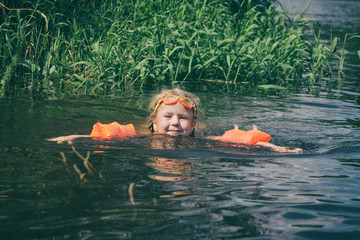 A child bathes in a summer river.