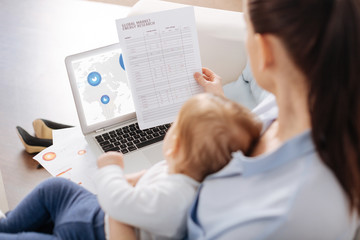 Clever ambitious gentle mother studying some data