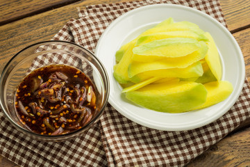 Mango-with-sweet-fish-sauce on wood table.