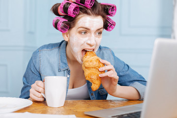 Excited lady watching serial during breakfast