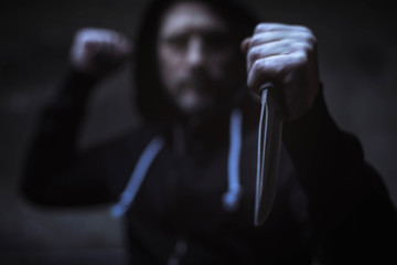 Hateful street hooligan threatening with a knife