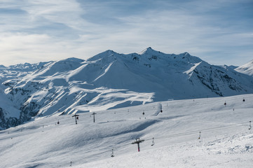 Snowy winter mountains in sun day. Caucasus Mountains, Georgia, from ski resort Gudauri