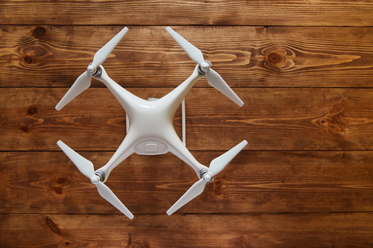 Drone quadcopter on the old wooden background with a copy space. Top view, flat lay composition.