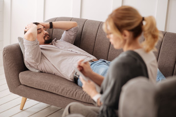 Depressed cheerless man lying on the couch