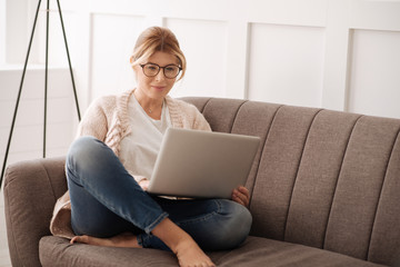 Cheerful blonde woman resting on the sofa