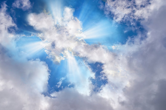 Light or sun rays bursting from the clouds in shape of a cross