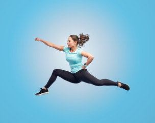 happy sporty young woman jumping in fighting pose